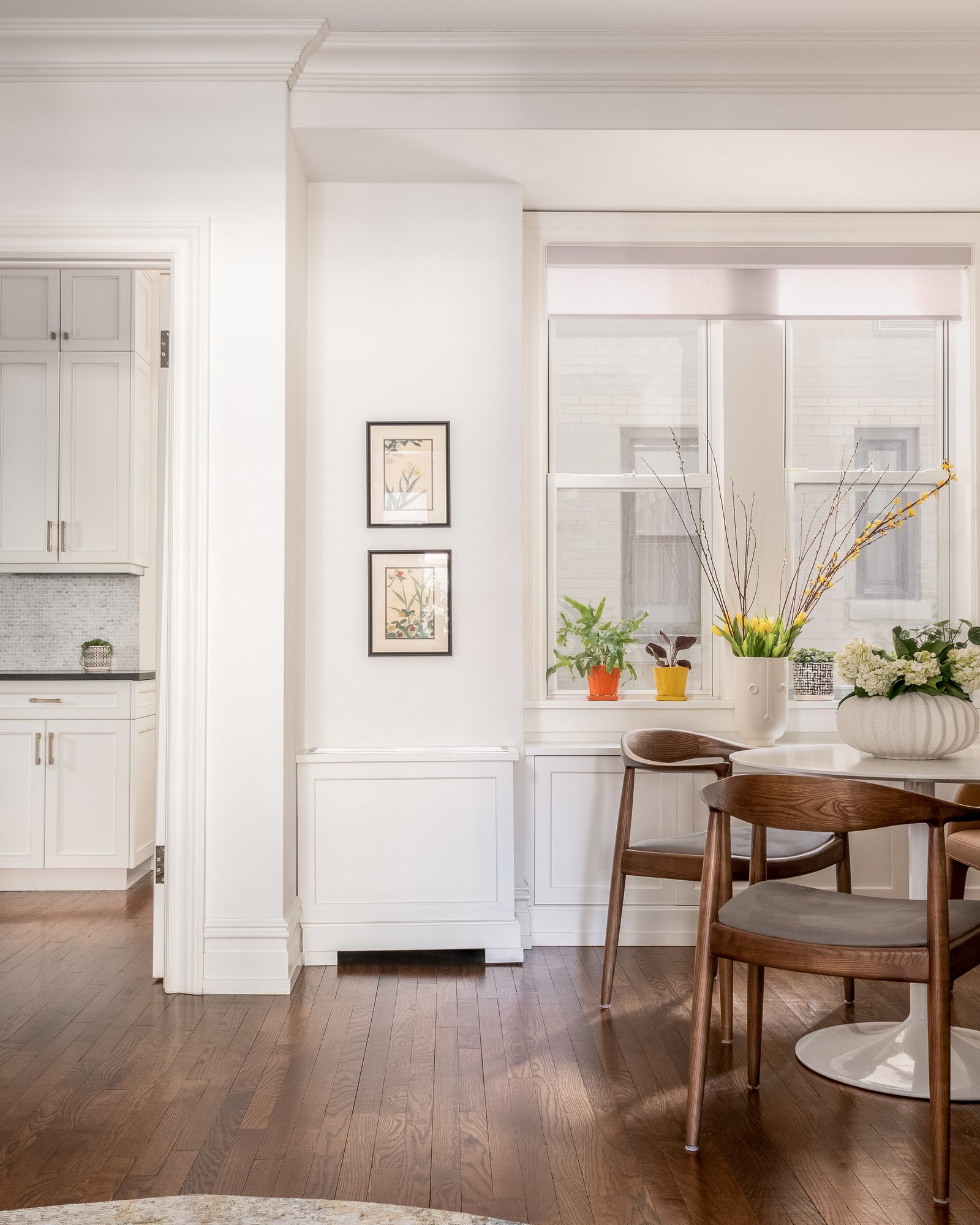 A view through a prewar doorway into an Upper West Side dining room with framed art and a round table
