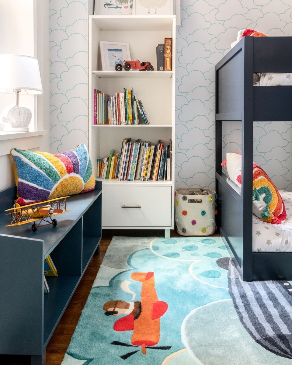 A bookcase and toy storage beside bunk beds