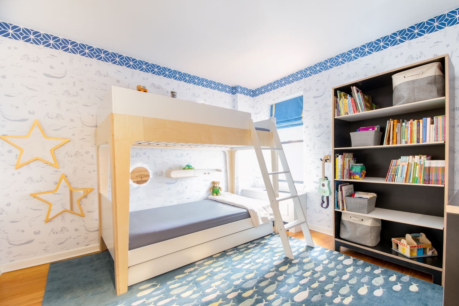 A children's room with bunk beds, cloud wallpaper and star lights