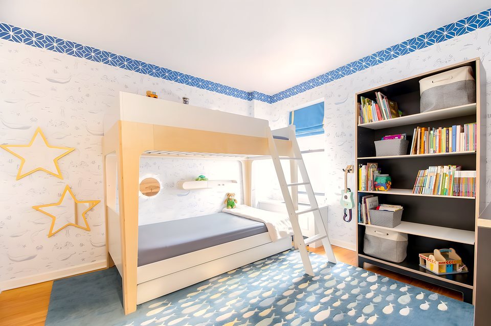 Overview of the boys' room with custom bed and characterful wallpaper