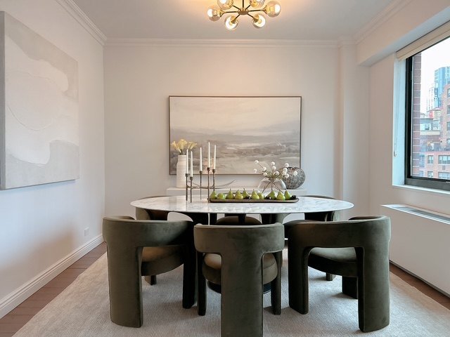 A round dining table with sculptural green chairs
